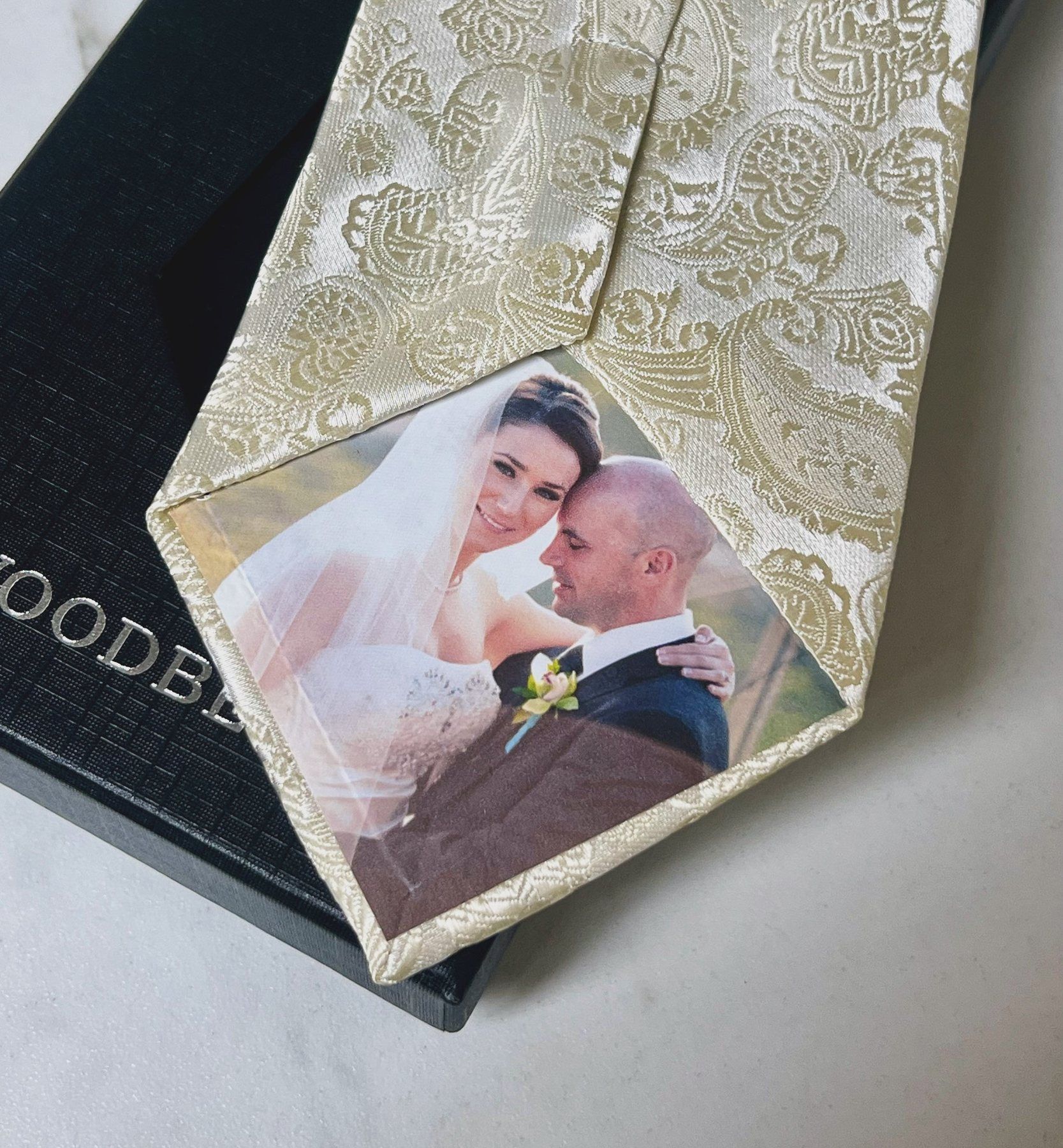 Personalized photo silk tie in champagne damask with a bride and groom photo on the tip, resting on a black Woodbe Co. box