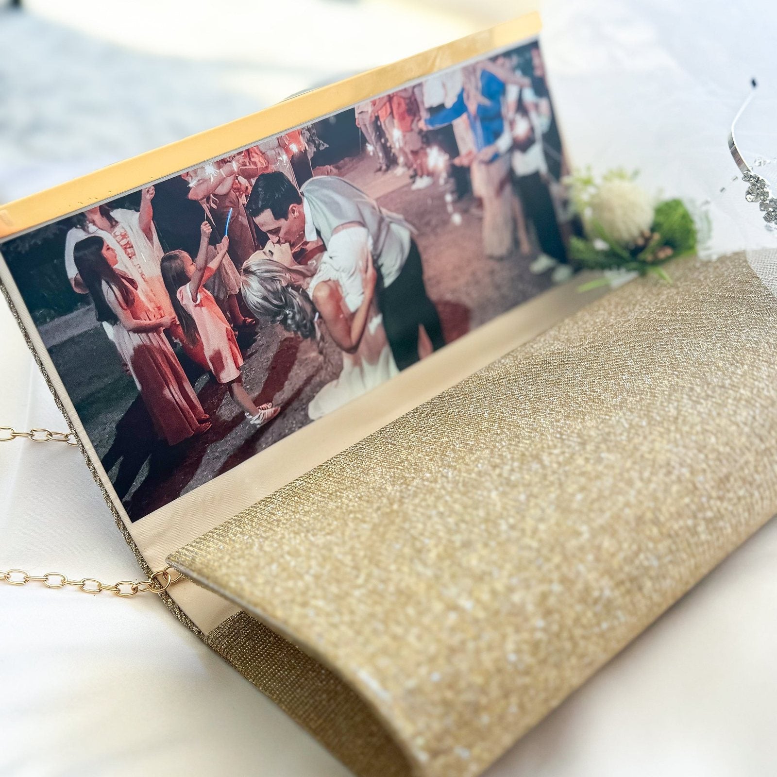 Gold sparkle clutch opened to show a personalized wedding photo