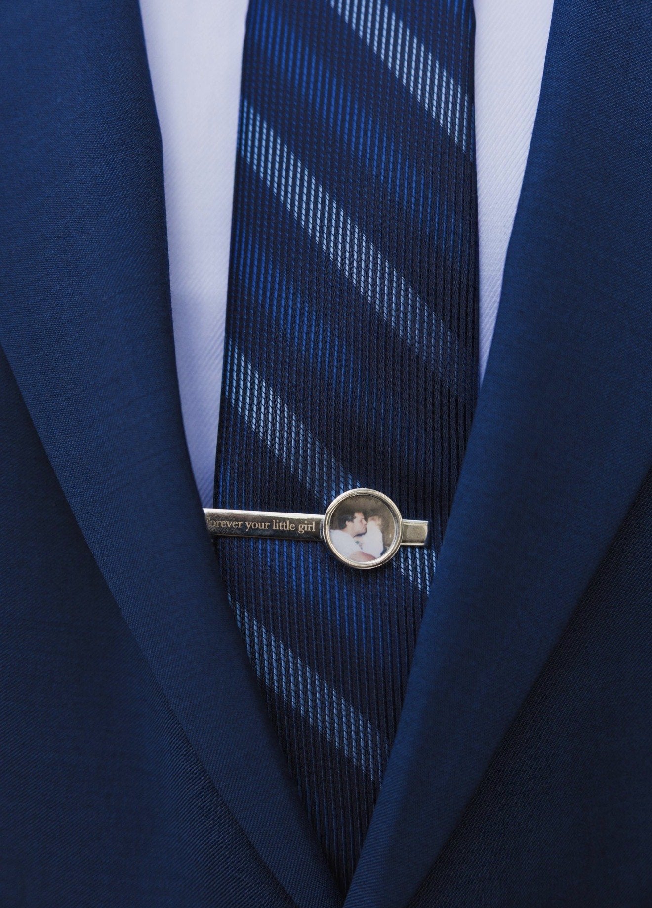 Silver photo tie clip engraved “forever your little girl” on a navy striped tie with a navy suit